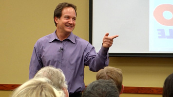 Jim Link pointing to a person in the crowd during a presentation