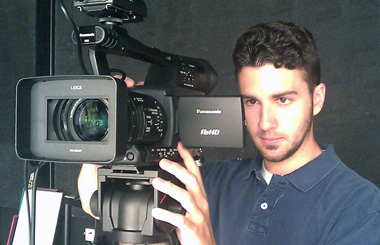 Photo of Ryan operating a digital video camera.